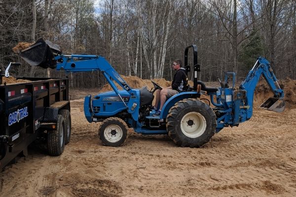 LS traktor s FEL-om i rovokopačem za utovar pijeska